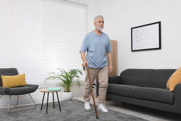 Senior man with walking cane at home - Foto, immagini