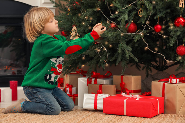 Little child decorating Christmas tree at home - Fotografie, Obrázek