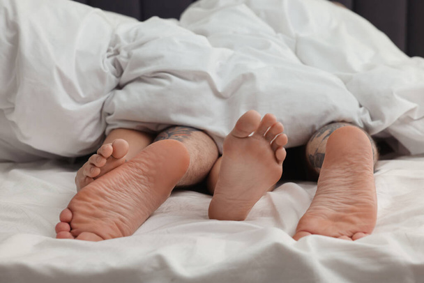 Passionate couple having sex on bed, closeup of legs - Фото, зображення