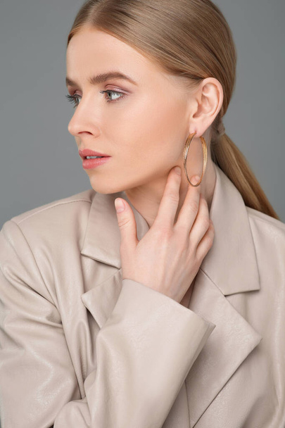 Beautiful young woman with elegant earrings on gray background - Valokuva, kuva