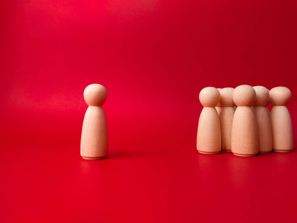A group of wooden statues with leader on a red background - Photo, Image