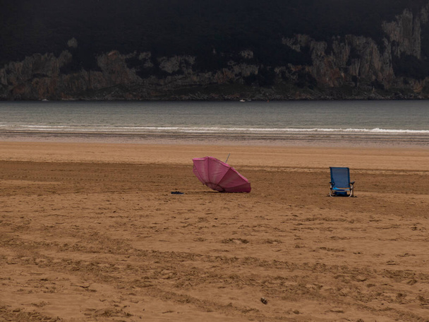 Retiro costeiro feliz: Serene Haven com guarda-chuva rosa e cadeira de praia azul - Foto, Imagem