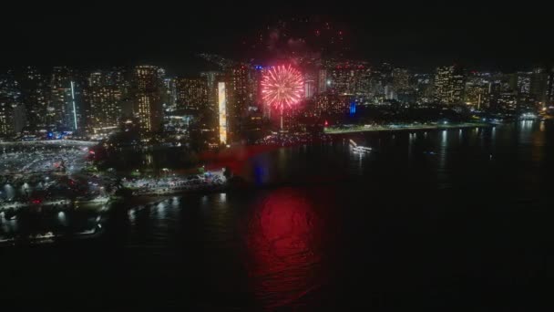 Vista aérea Fuegos artificiales en el cielo Waikiki. Nochevieja en la ciudad de Honolulu. Gente celebrando con fuegos artificiales brillantes en la isla de Oahu durante las vacaciones hawaianas. Explosión brillante de fuegos artificiales en el horizonte urbano - Imágenes, Vídeo