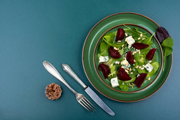 Salada com beterraba fervida, queijo azul, ervas e pinhões. Fundo de receita de alimentos. Espaço de cópia - Foto, Imagem