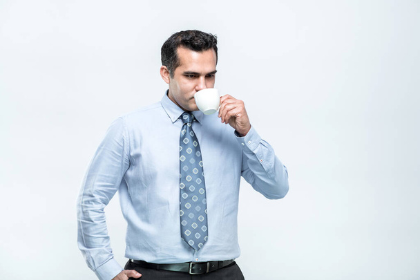 La imagen de un empleado asiático tomando café mientras está en el descanso de Blake con comodidad y una cara fresca, sobre un fondo blanco. - Foto, imagen