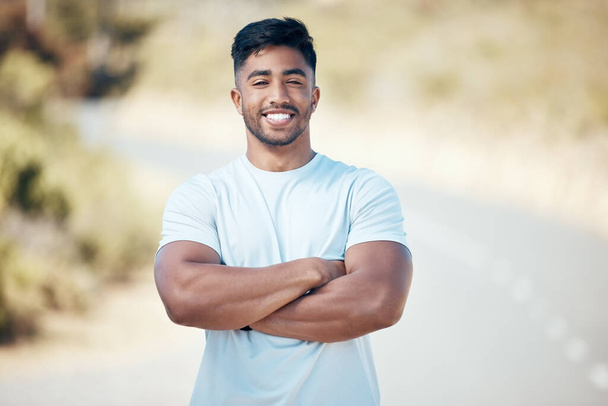 Fitness, portrait and man with arms crossed on a road with happiness from run and sport. Face, smile and confidence from wellness, workout and runner exercise on a urban street outdoor feeling happy. - Photo, image