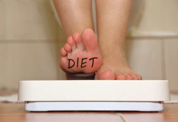 Ноги на шкале ванной комнаты с нарисованным вручную текстом диеты
 - Фото, изображение