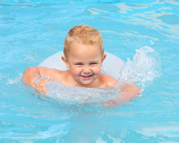 Junge mit Rettungsring genießt das Leben im Schwimmbad. - Foto, Bild