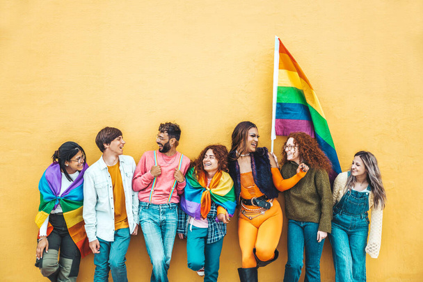 Lgbt community concept met jongens en meisjes knuffelen samen buiten - Multiraciale trendy vrienden staan op een gele achtergrond - Foto, afbeelding