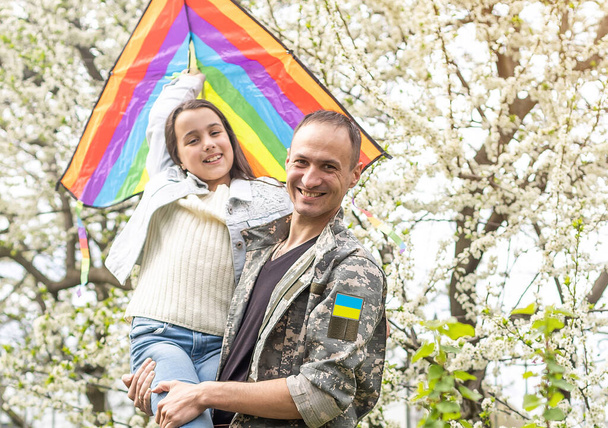 Vater in ukrainischer Militäruniform und seine Tochter. Familienzusammenführung. - Foto, Bild
