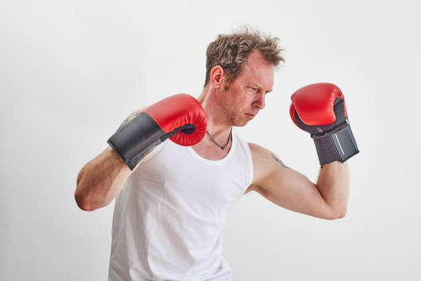 Man with red boxing and punching gloves - 写真・画像