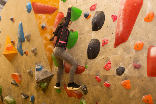 teenager climbing a rock wall. - Photo, Image