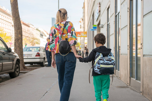 Милый маленький мальчик ходит в школу со своей матерью
 - Фото, изображение