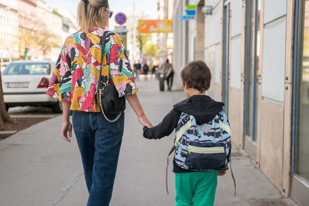 Милый маленький мальчик ходит в школу со своей матерью
 - Фото, изображение