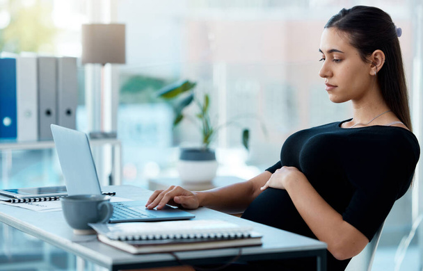 Деловая женщина, беременная и сидящая в офисе с ноутбуком, с поиском или проектом в финансовой компании. Беременная деловая женщина, бухгалтер и компьютер за столом с планированием, графиком и трогательным желудком. - Фото, изображение