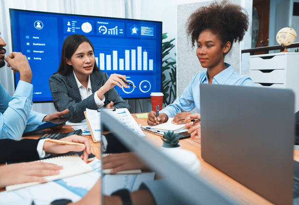 Multiracial analyst team use BI dashboard data to analyze financial report on meeting table. Group of diverse business people utilize data analysis by FIntech for business marketing decision. Concord - Photo, Image
