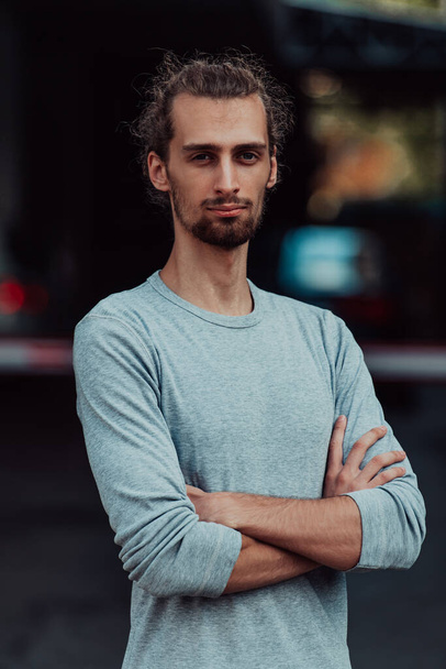 Portrait of a young successful businessman with crossed arms in front of the company. High quality photo - Zdjęcie, obraz