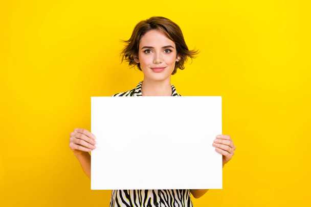 Photo of cheerful positive lady wear animal print shirt holding placard empty space isolated yellow color background. - Photo, image