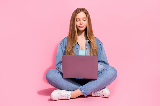 Photo of pretty cute girl wear stylish clothes sitting floor listening online lesson writing homework isolated on pink color background. - Fotó, kép