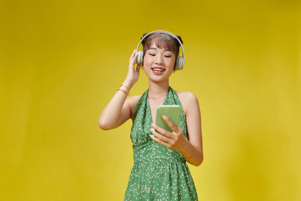 Cute girl utilise des écouteurs sans fil. - Photo, image