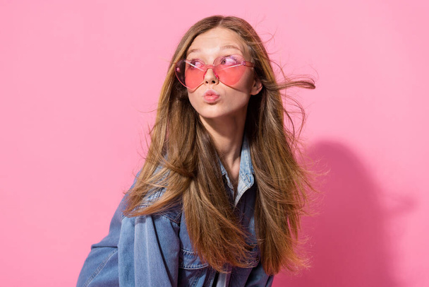 Photo portrait of lovely young teenager lady pouted lips look empty space wear trendy jeans garment isolated on pink color background. - Zdjęcie, obraz