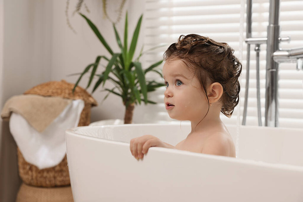 Cute little girl washing hair with shampoo in bathroom - Φωτογραφία, εικόνα