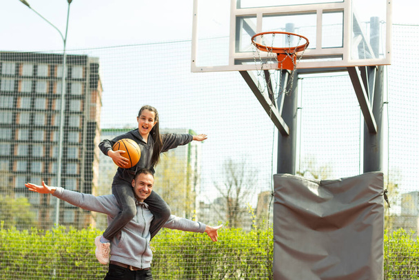 Pai feliz e filha adolescente fora na quadra de basquete - Foto, Imagem
