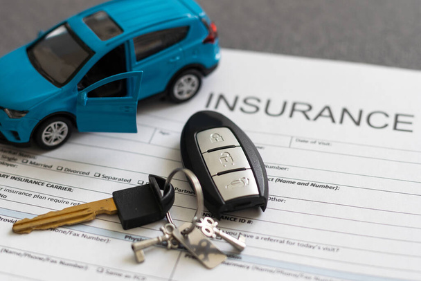 Formulario de reclamación de seguro de automóvil y coche de juguete. - Foto, imagen