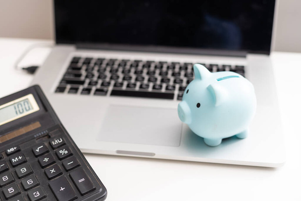 Piggy Bank с ноутбуком, что означает зарабатывать деньги в Интернете или бизнес-концепции
. - Фото, изображение