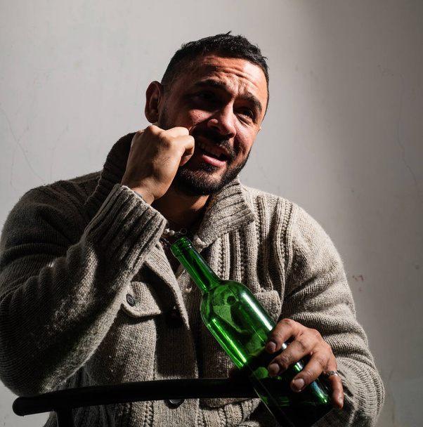 He is binge drinking. Hispanic man suffering from unhealthy alcohol drinking dependance. Anonymous alcoholic having drinking problem. Depressed latino man drinking alcoholic drink from bottle. - Foto, Imagem