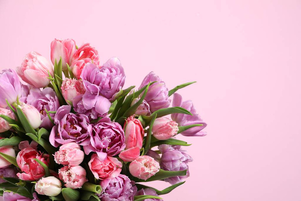 Beautiful bouquet of colorful tulip flowers on pink background. Space for text - Photo, Image