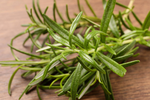 Fresh green rosemary on wooden table, closeup - Photo, image