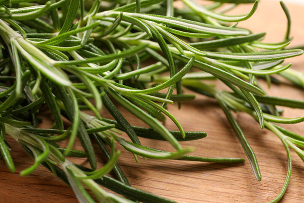 Sprigs of fresh rosemary on wooden board, closeup - Photo, image
