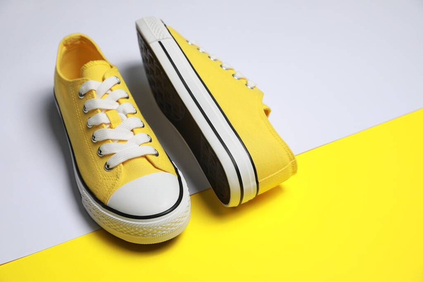 Pair of yellow classic old school sneakers on color background - Foto, Imagem