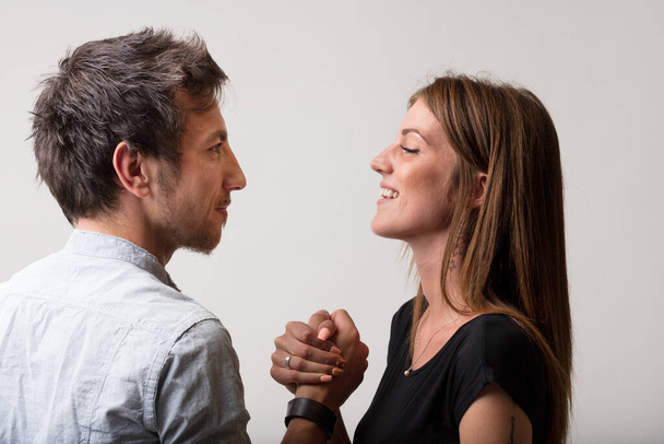 Man and woman, playfully defiant, engage in arm wrestling, embodying the dichotomy of friends and lovers, rivals and competitors, but always with a sense of fairness and fun - Фото, изображение