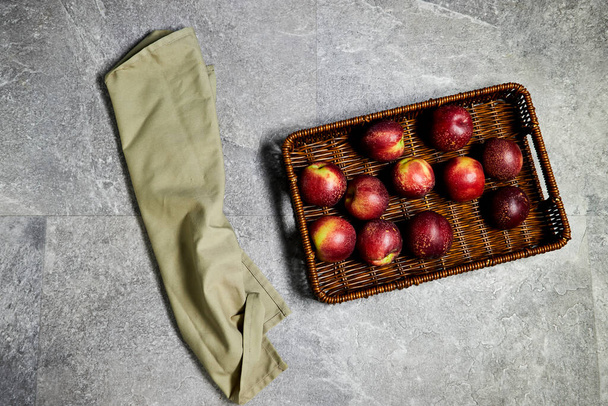 Fresh sweet ripe peaches in basket on gray grunge background - Photo, Image