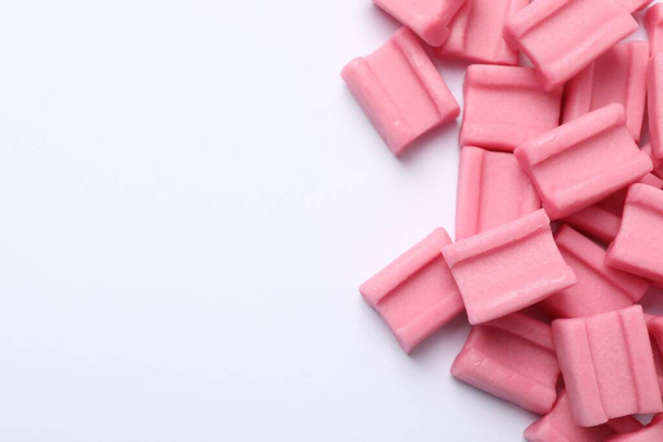 Tasty pink chewing gums on white background, flat lay. Space for text - Zdjęcie, obraz