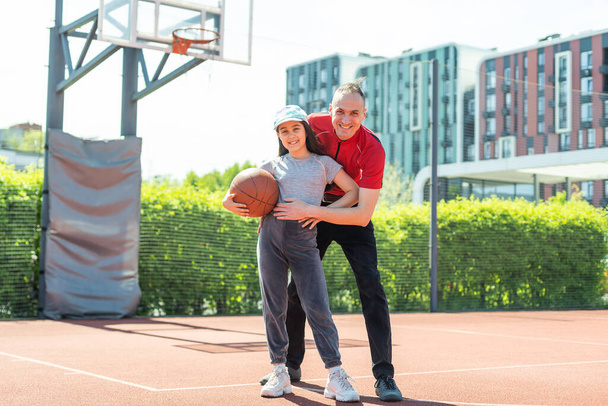 батько і дочка грають у баскетбол разом на дитячому майданчику
. - Фото, зображення