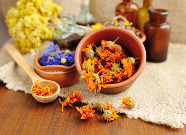 Curación de hierbas y tinturas en botellas de tela de saco, flores secas, hierbas medicinales
 - Foto, Imagen