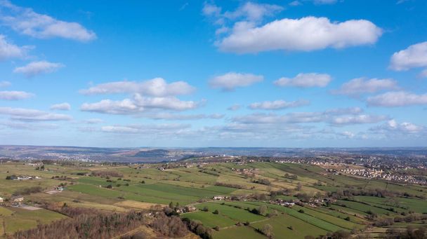 Zdjęcie drona lotniczego pięknego miasta Thornton w Bradford w Wielkiej Brytanii, pokazujące pola rolników wiosną w upalny słoneczny dzień z chmurami na niebie. - Zdjęcie, obraz