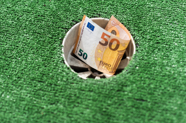 Pilha de dinheiro no buraco do campo de golfe - conceito de tiro de dinheiro - Foto, Imagem