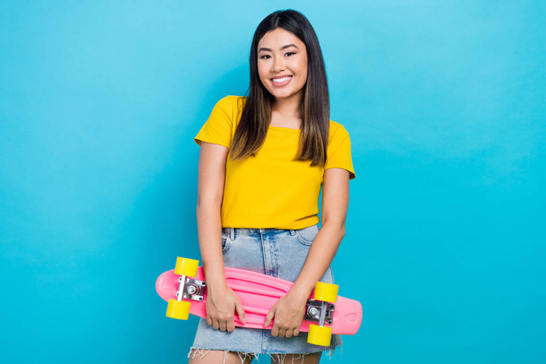 Photo of summertime season lover korean girl funky hold penny board skate have fun wear mini skirt isolated on blue color background. - Foto, imagen