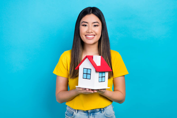 Photo of vietnamese young lady hold her new house buy insurance for rent apartment safe credit money isolated on blue color background. - Foto, immagini