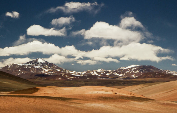 View of the desert and Andes mountains with snowy peaks under a beautiful sky with clouds  - Valokuva, kuva