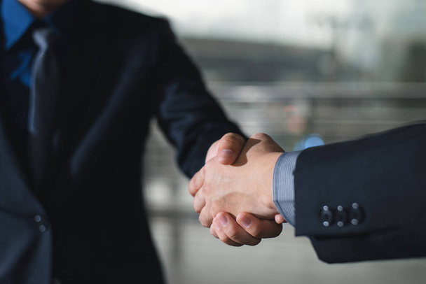 Business etiquette, congratulations, and merger and acquisition principles are demonstrated by a businessman shaking hands with his partner at the office. - Foto, Imagem