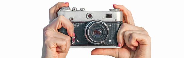 Kamera retro w kobiecych dłoniach z bliska. Kobieta trzyma aparat fotograficzny na białym tle. Projekt banera - Zdjęcie, obraz