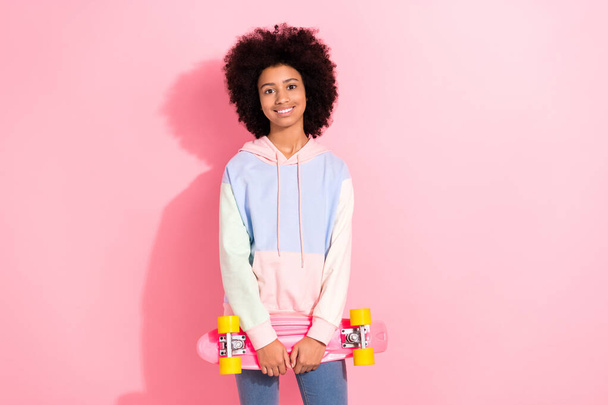 Photo of positive sweet small kid wear sweatshirt smiling holding penny board isolated pink color background. - Foto, afbeelding