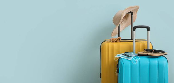 Pakatut matkalaukut, joissa on passit, lääketieteelliset naamarit ja matkatarvikkeet vaaleansinisellä pohjalla ja tilaa tekstille - Valokuva, kuva