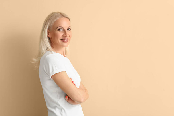 Mature blonde woman on beige background - Photo, Image