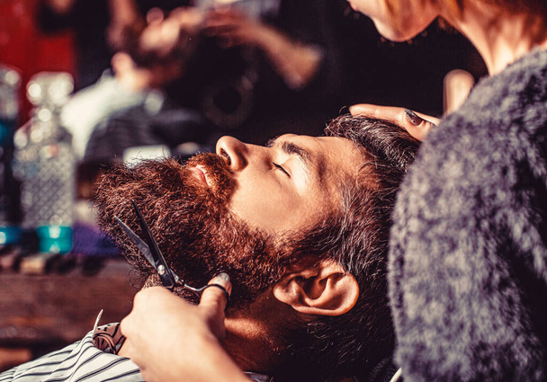 Man hairstylist. Beard man in barbershop. Hairstylist serving client at barber shop, bearded. Hairdresser, hair salon. Barber scissors, barber shop. Vintage barbershop, shaving. - Photo, Image